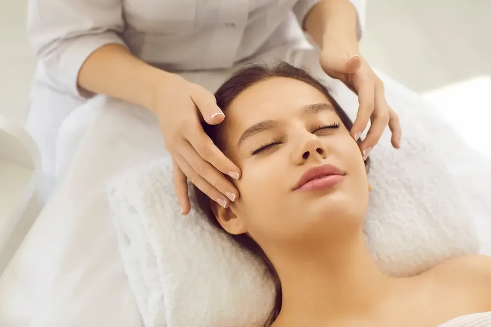 Frau entspannt sich während einer Gesichtsbehandlung in einer ästhetischen Klinik